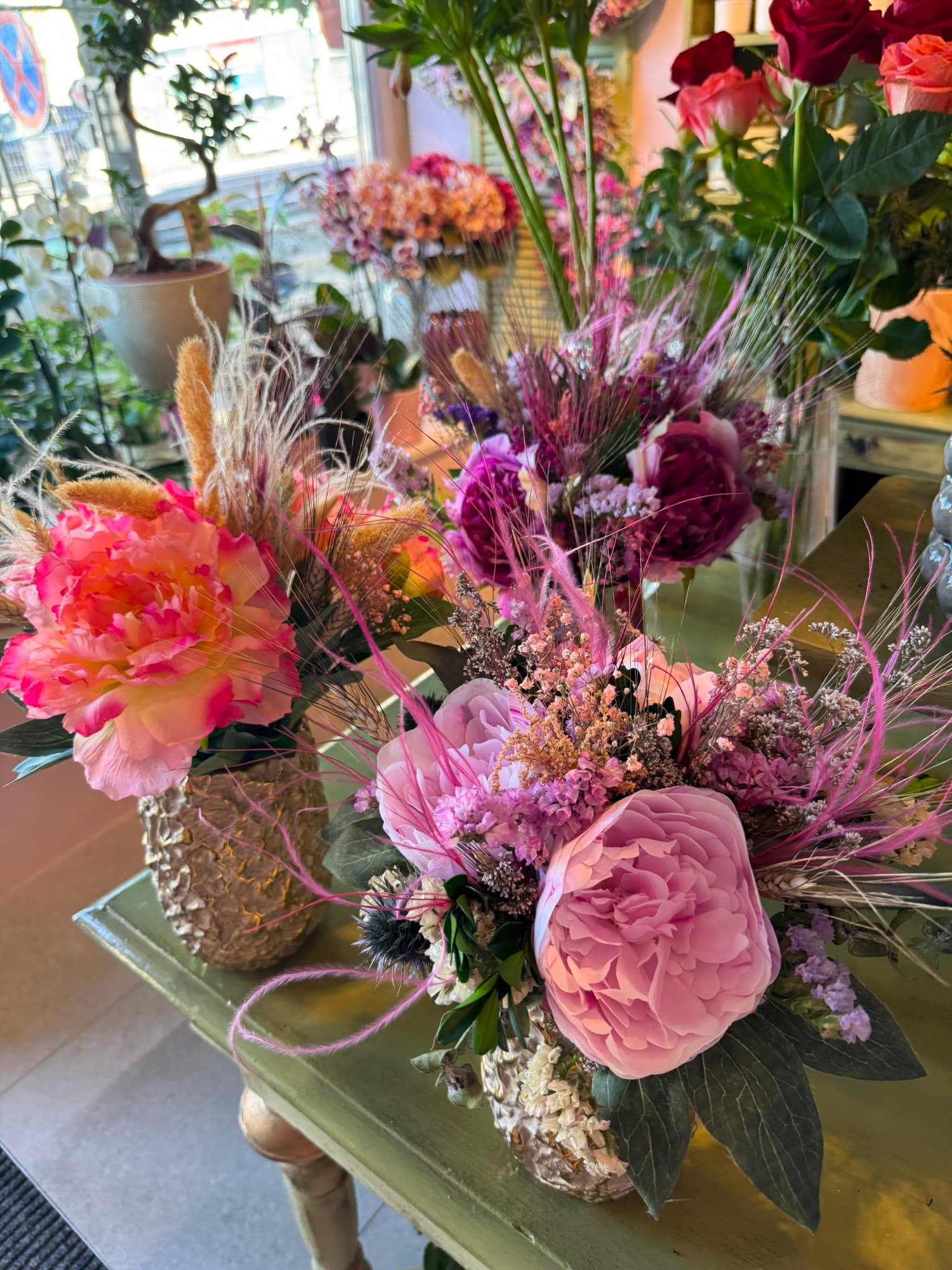 A dried arrangement in burgundy and peach tones